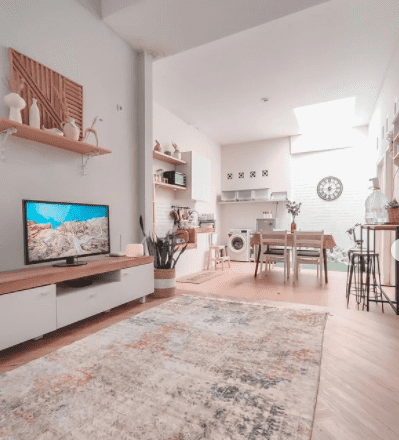 Desain interior rumah minimalis tanpa sekat dengan ruang TV berkarpet